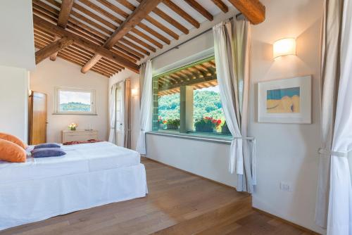 ein Schlafzimmer mit einem Bett und einem großen Fenster in der Unterkunft Tenuta Bellafonte 14, Emma Villas in Bevagna