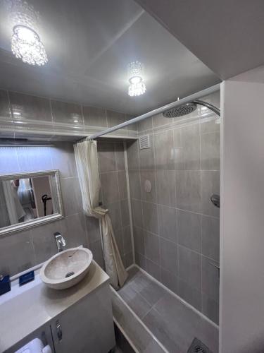 W łazience znajduje się umywalka i prysznic. w obiekcie Уютная 3 комнатная квартира w mieście Uralsk