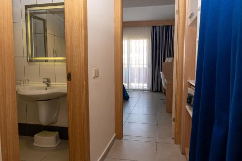 a bathroom with a sink and a mirror at AQI Pegasos World in Side