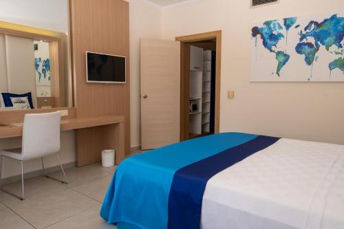 a bedroom with a desk and a bed with a blue blanket at AQI Pegasos World in Side