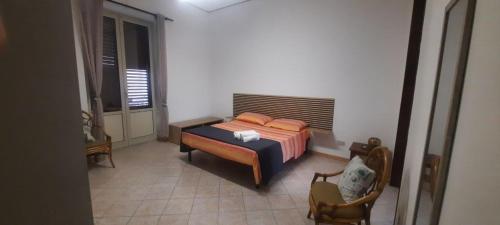 a bedroom with a bed and a chair in it at Angelina's cozy home in Capaci