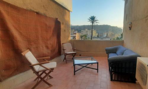 a living room with chairs and a couch and a table at Angelina's cozy home in Capaci