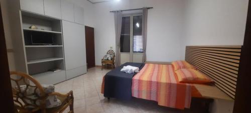 a small bedroom with a bed and a television at Angelina's cozy home in Capaci