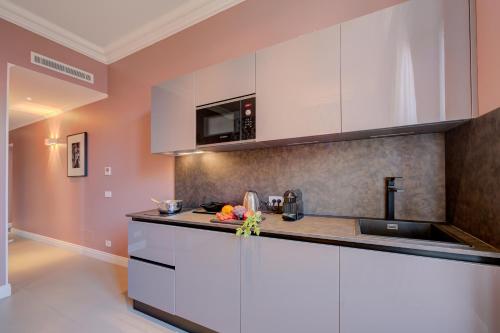 a kitchen with white cabinets and a counter top at Seven Suites Apartments - Via Matteotti 178 in Sanremo