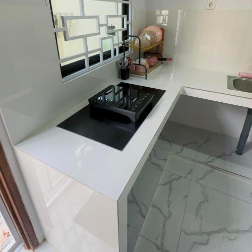 bagno con pavimenti in marmo bianco e specchio di Holiday Homestay Singkawang a Sedau