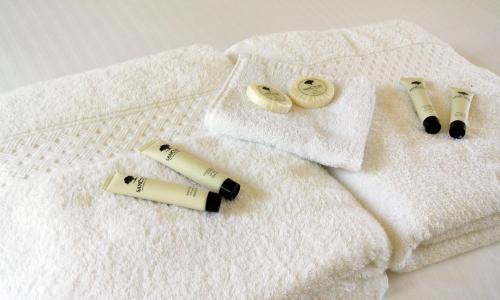 a white towel with two rolls of mascara and two bottles of lipstick at Motel Miramar in Nambucca Heads