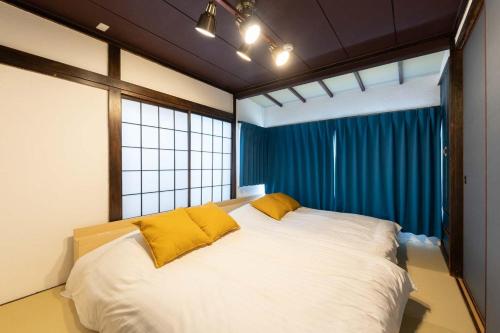 a bedroom with a large white bed with yellow pillows at Kisa in Tokyo