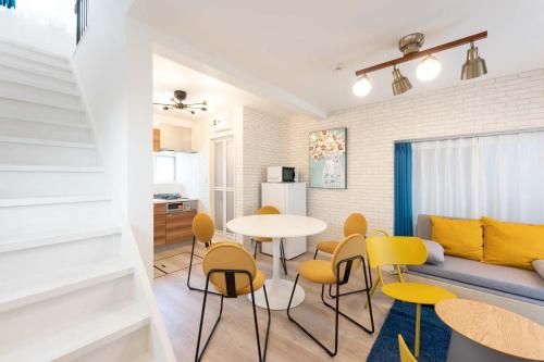 a living room with a table and yellow chairs at Kisa in Tokyo