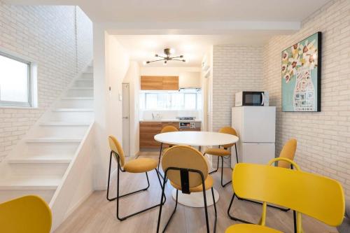 a kitchen and dining room with a table and yellow chairs at Kisa in Tokyo