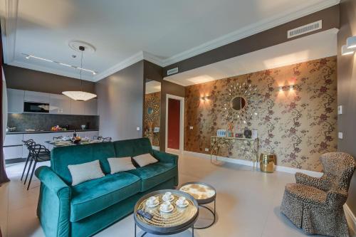 uma sala de estar com um sofá verde e uma cozinha em Boutique Central Apartments- Happy Rentals em Sanremo