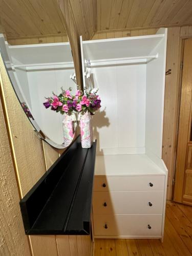 a room with a mirror and flowers on a counter at Zagroda Dębki in Dębki