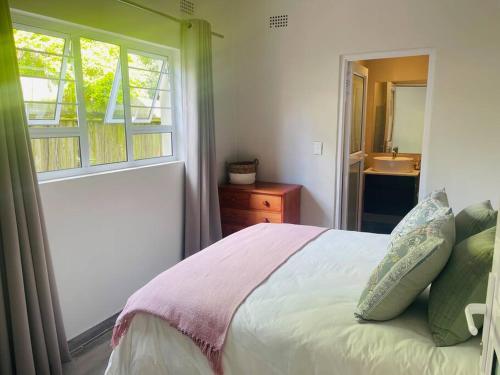 a bedroom with a bed and a window and a sink at Whitehouse cottage in White River