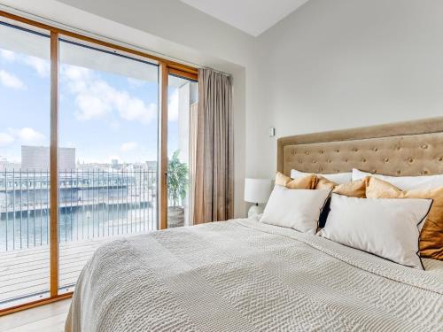 een slaapkamer met een groot bed en een groot raam bij Sanders View Copenhagen - Stunning Two-Bedroom Apartment with harbor view in Kopenhagen