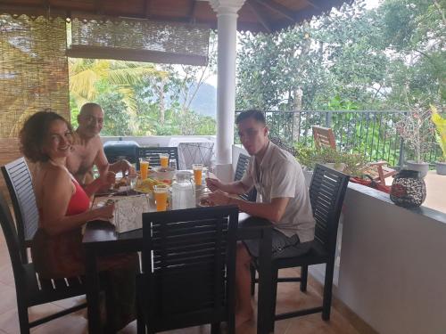 a group of people sitting at a table at Hideaway Homestay kandy in Haloluwa