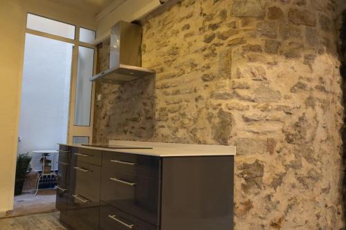 - une cuisine avec un mur en pierre et un comptoir dans l'établissement Nueva casa boutique en el centro de Sevilla, à Séville