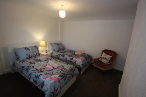 a small bedroom with a bed and a chair at Lymm Cottage in Lymm