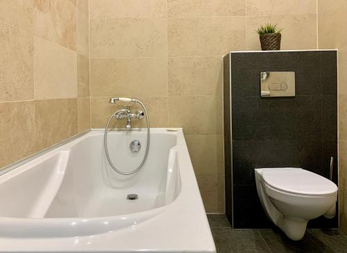 une salle de bain avec une baignoire blanche et des toilettes dans l'établissement New Vintage house with Netflix Füge és könyvtár, à Keszthely
