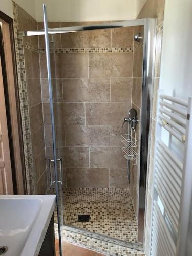 une douche avec une porte vitrée à côté d'un lavabo dans l'établissement Appartement dans bastide à Saint Rémy de Provence, à Saint-Rémy-de-Provence