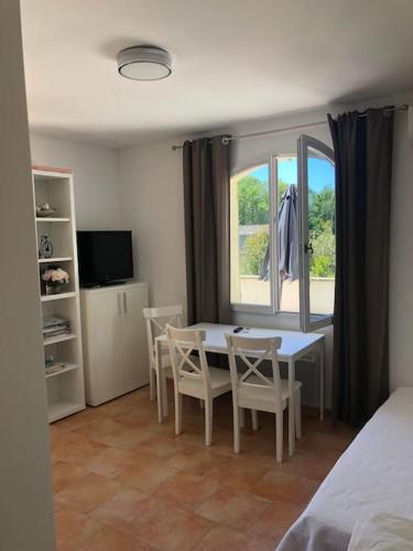 - une chambre avec une table, des chaises et une fenêtre dans l'établissement Appartement dans bastide à Saint Rémy de Provence, à Saint-Rémy-de-Provence