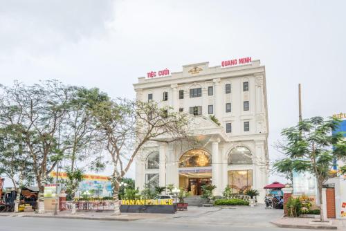 a white building with trees in front of it at Tan An Palace in Hai Phong