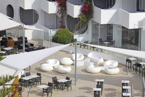 an outdoor seating area with tables and chairs in a building at BG Pamplona in Playa de Palma
