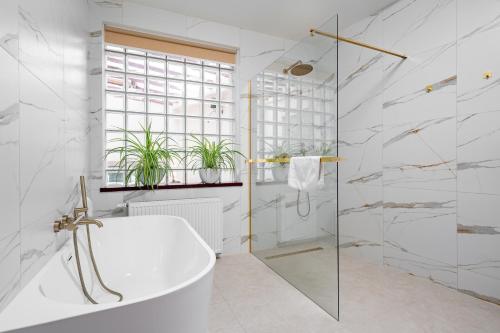 uma casa de banho branca com uma banheira e um chuveiro em Gotyk em Toruń