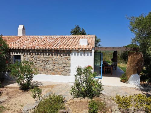 a stone house with a pathway leading to a patio at Newly renovated traditional Sardinian dwelling in Porto Rotondo