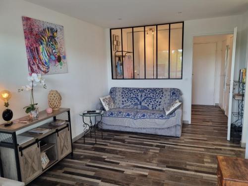 a living room with a couch and a table at Superbe T2 tout confort 3 étoiles, entièrement renové avec piscine, parking, clim, wifi, Netflix in La Grande-Motte