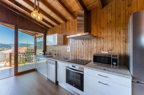 a kitchen with white appliances and wooden walls at Fernandes Guest house Yellow Bungalow in Ponte de Lima