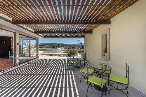 a patio with chairs and tables and a wooden ceiling at Fernandes Guest house Yellow Bungalow in Ponte de Lima