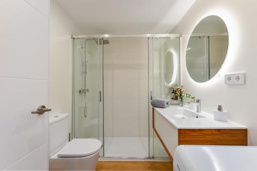 y baño con ducha, aseo y lavamanos. en Golden Bay Apartment en Estepona
