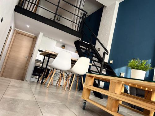 een woonkamer met witte stoelen en een trap bij 48 Downtown Lofts in Néa Péramos
