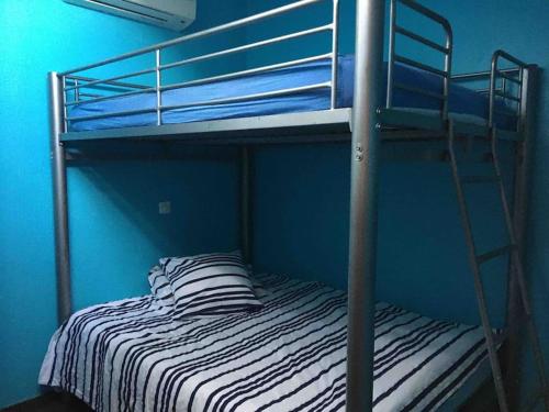 a bunk bed in a blue room with a ladder at Villa avec piscine, parking, clim in Palavas-les-Flots