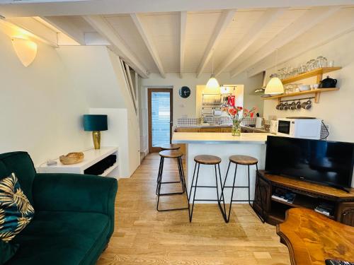 a living room with a couch and a kitchen at Alexander cottage in Penryn