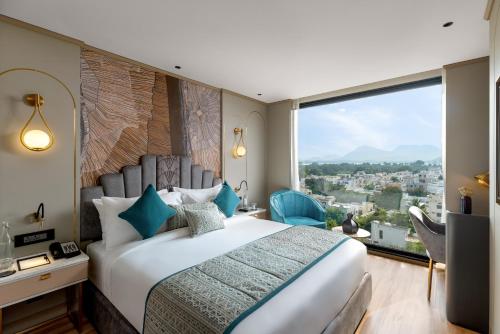 a bedroom with a large bed and a large window at Parallel Hotel Udaipur - A Stylish Urban Oasis in Udaipur