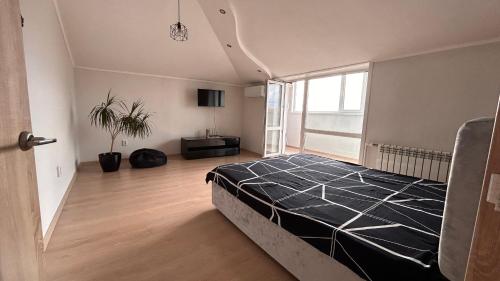 1 dormitorio con cama y ventana grande en Квартира в центре Костаная, en Kostanái