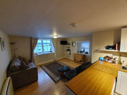 a living room with a couch and a table at Waterfront Apartment, St Margarets Hope, Orkney in St Margaret's Hope