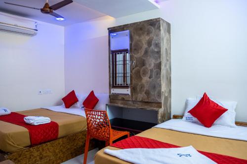 a hotel room with two beds and a window at Le Suresh Guest House in Puducherry