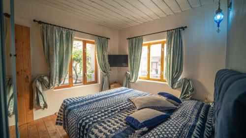 a bedroom with a blue and white bed with windows at Cozy Oasis with Lovely Backyard in Fethiye in Fethiye