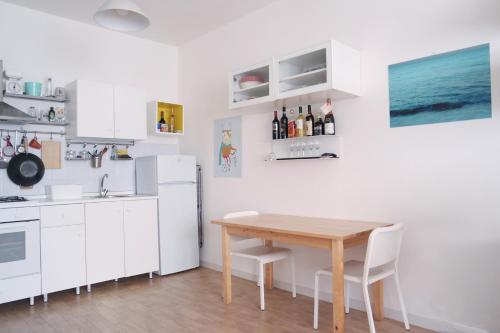 a kitchen with a wooden table and white cabinets at CM b&b Piramide in Rome