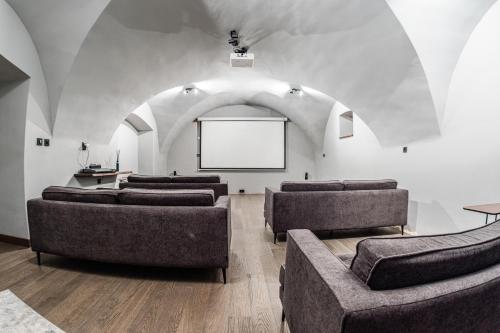 a room with several couches and a screen in a building at Villa Zara Boutique Hotel Resort in Smolník