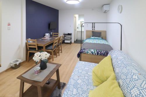 ein Wohnzimmer mit einem Bett und einem Tisch mit einem Sofa in der Unterkunft Furinkyo・楓林居 3号館 in Osaka