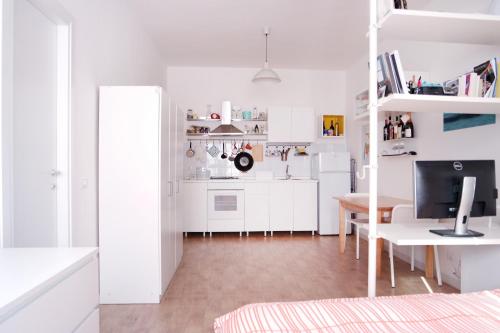 a white apartment with a desk and a kitchen at CM b&b Piramide in Rome