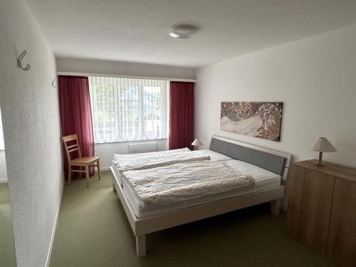 a bedroom with a bed and a window at GOLIATH in Leukerbad