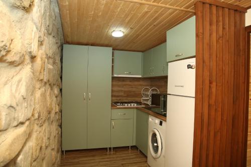 a kitchen with green cabinets and a white refrigerator at Kadori Hills in Tʼelavi