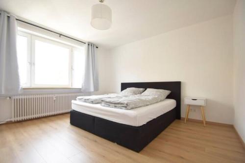 een bed in een kamer met een groot raam bij Air Apartments 13 in Bremen