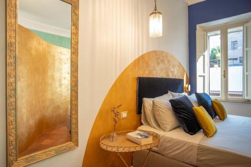 een slaapkamer met een bed met een spiegel en een tafel bij PgRhome Luxury Apartments Colosseo 11 BLU in Rome