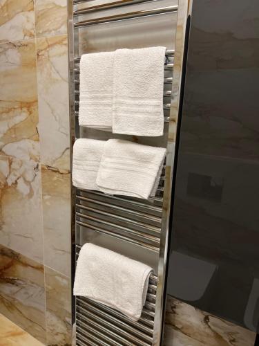 a towel rack with white towels in a bathroom at Appartamento feriolo Margherita in Baveno