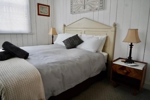 a bedroom with a large white bed and two lamps at Montrose on Moore in Linville