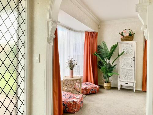 a living room with orange curtains and a window at Cosy House in Chartwell, Hamilton-Private Garden & Shopping Mall in Hamilton